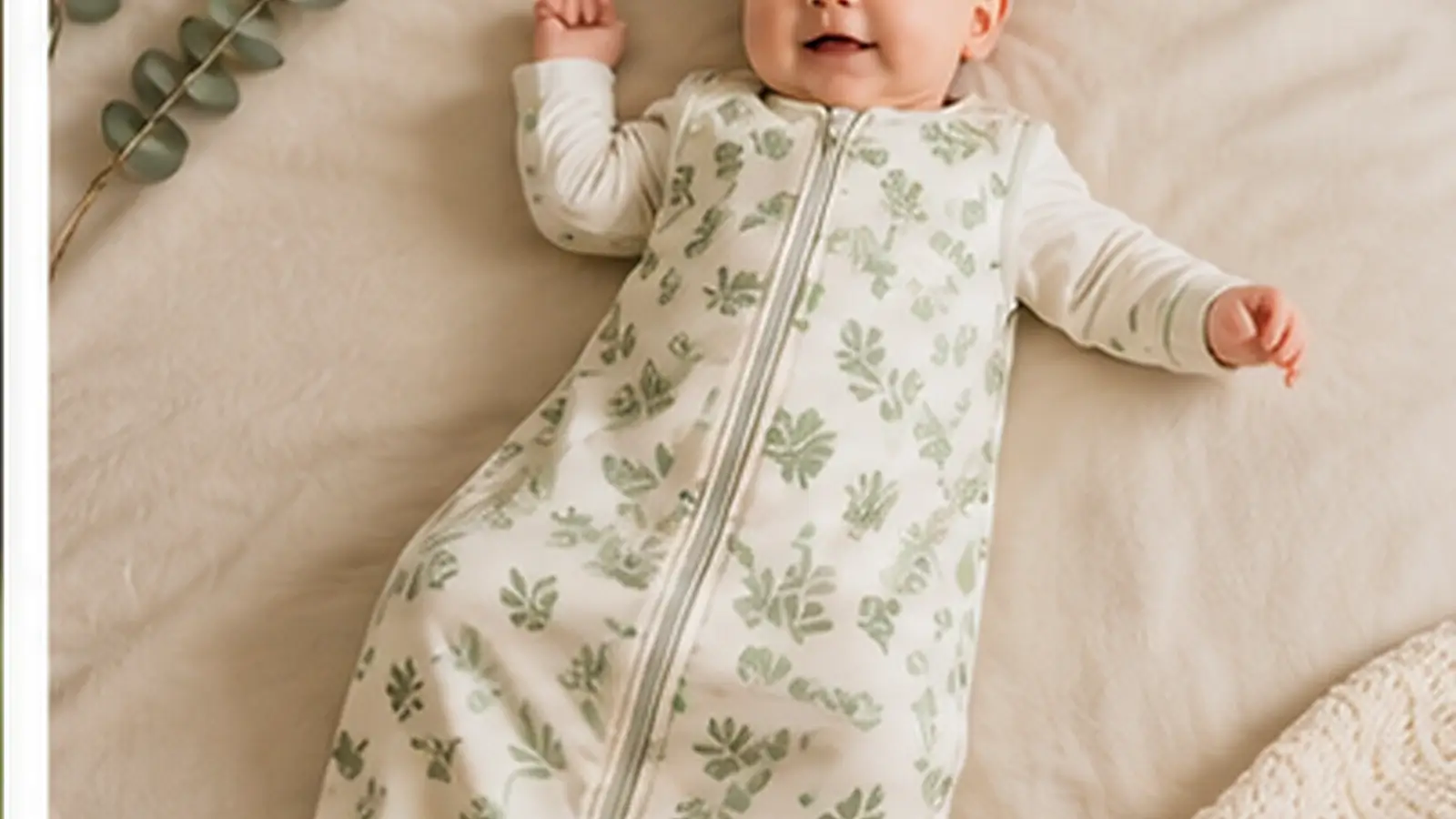 Realistic organic baby sleep sack hero image showing a comfortable baby resting safely in a soft botanical-pattern sleep sack on a cozy bed.