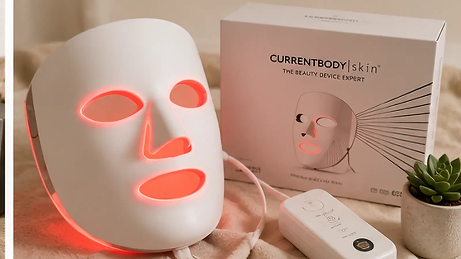 Realistic LED red light face mask hero image featuring a glowing facial therapy mask with its control device in a calm premium skincare setting.